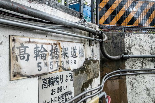 高輪橋架道路の架線と配管が複雑に張り巡らされた壁面