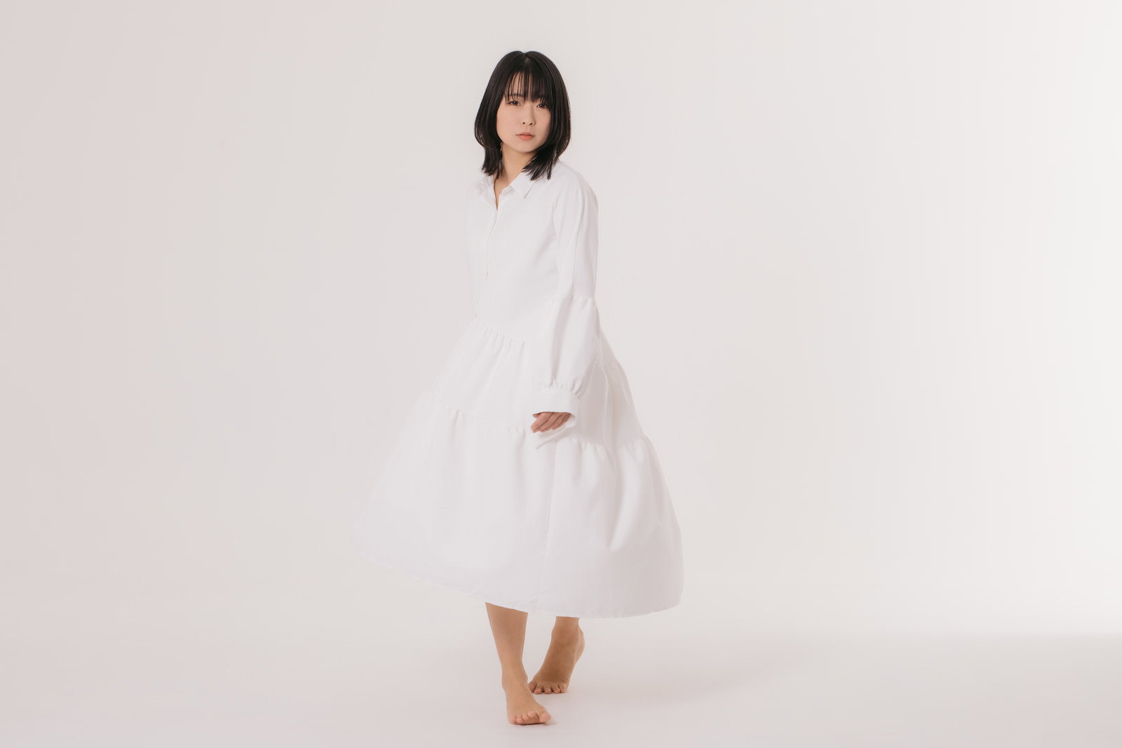 白いワンピースを着て歩き出す女性のポートレート写真［モデル：にゃるる］