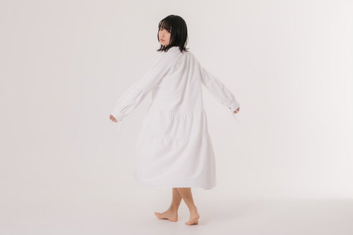 振り向き様に不機嫌な表情の白いワンピース姿の女性