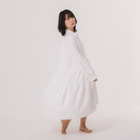 白いワンピースを着て振り返る女性の写真
