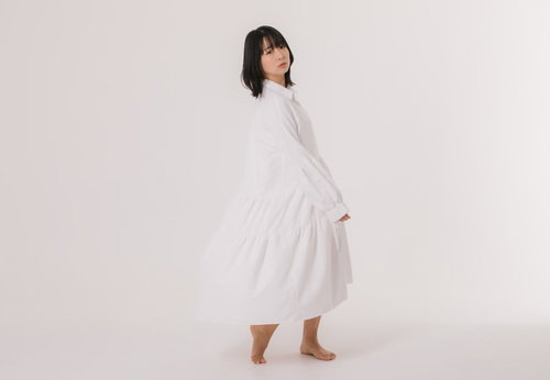 白いワンピースを着て振り返る女性