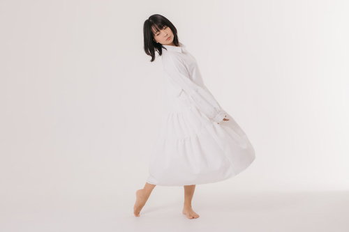 左右に体を揺らすワンピース姿の女性のポージング