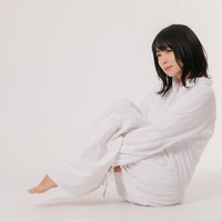 白いワンピースで小山座りするリラックスポーズの女性の写真