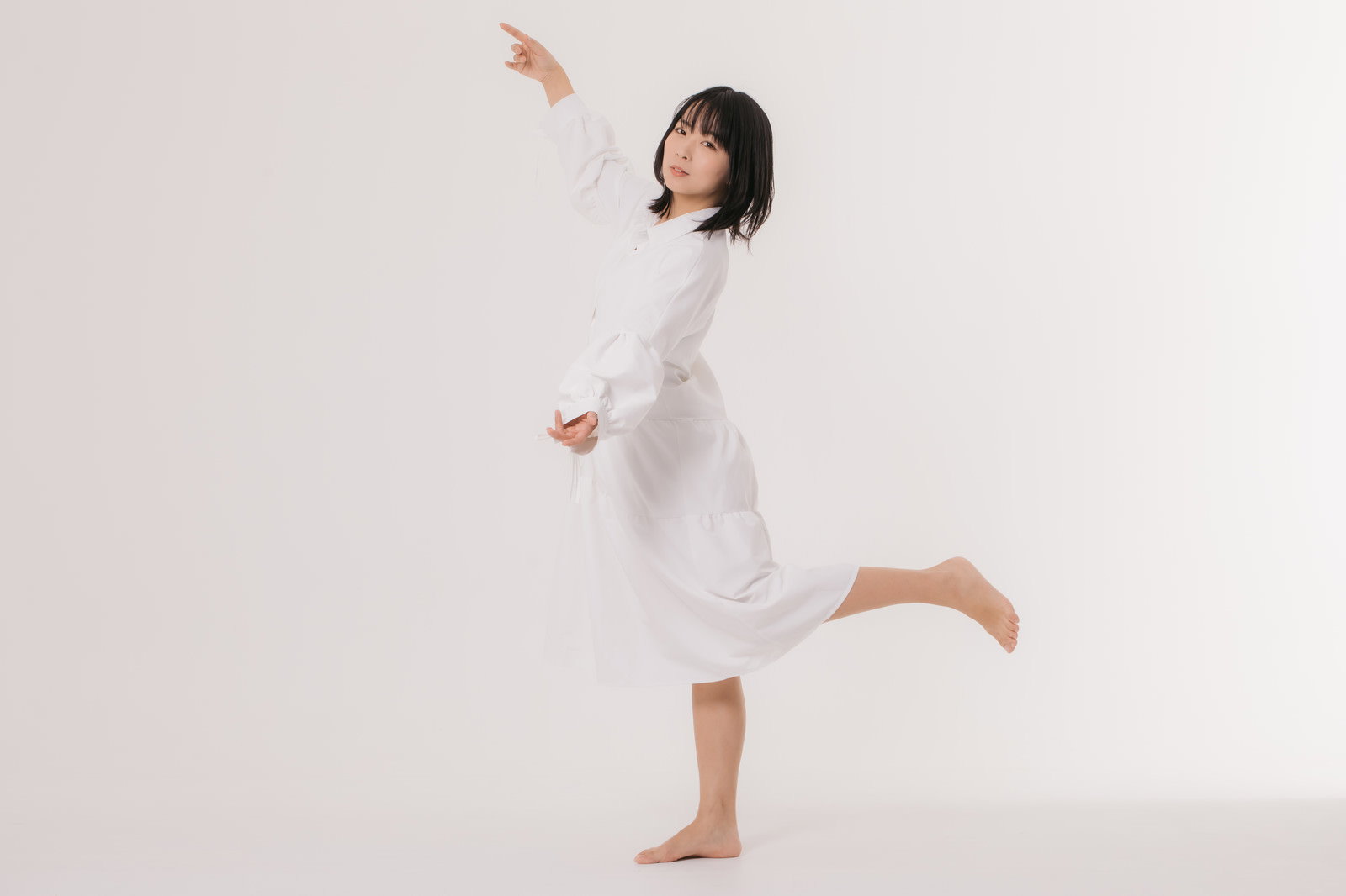 白いワンピース姿の女性が片足立ちでポーズを決めている［モデル：にゃるる］