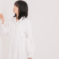 壁の薄さが気になって軽くノックする女性のポーズの写真