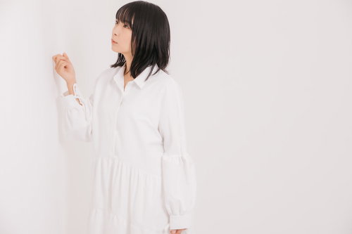 壁の薄さが気になって軽くノックする女性のポーズ