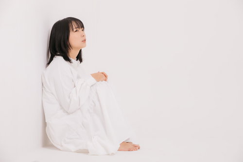 隅っこで膝を抱えて座り込む自粛する落ち込んだ女性