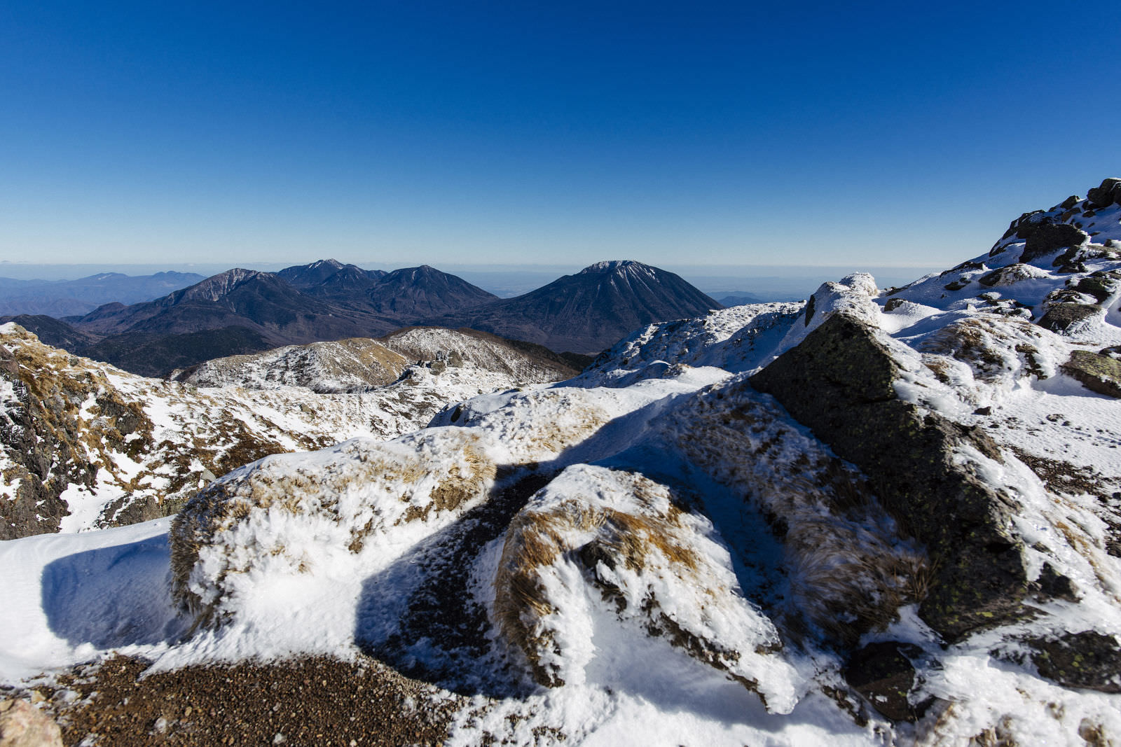 雪に覆われた日光白根山山頂から望む男体山の雪景色