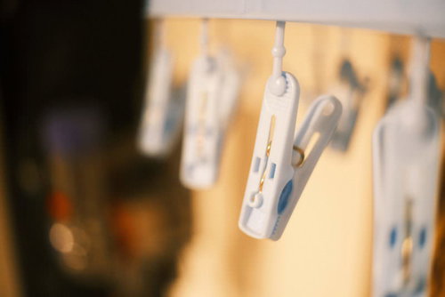 ベランダの物干しに並ぶ洗濯バサミと干された衣類