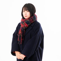 赤いチェック柄のマフラーを巻く女性の防寒姿の写真