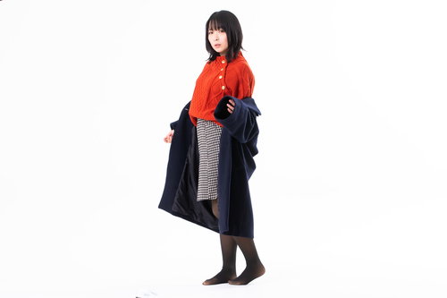 赤いコートを脱ぐ女性のポーズ、冬の季節の衣替え