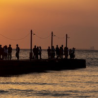 千葉県・原岡桟橋の夕暮れ時に集う人々と夕焼けの風景の写真