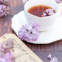 ライラックの花が添えられた紅茶のティータイムの写真