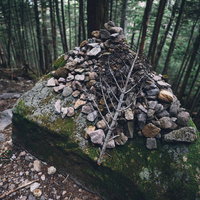 竹林の中に積み上げられたケルンの写真