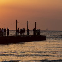 千葉県・原岡桟橋で夕景に佇む人々と夕焼けのシルエットの写真