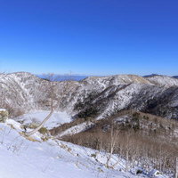 日光白根山山頂稜線から見る雪に覆われた五色沼方面の写真