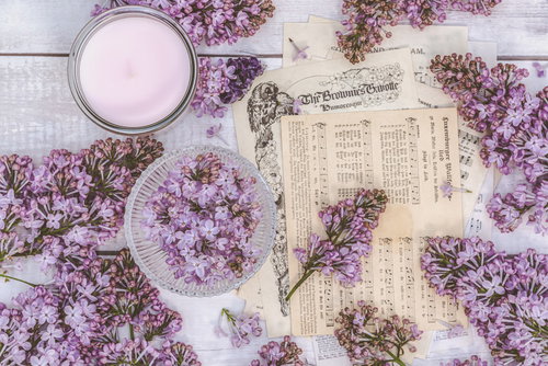 散らばるライラックの花と楽譜とキャンドルのテーブルスタイリング