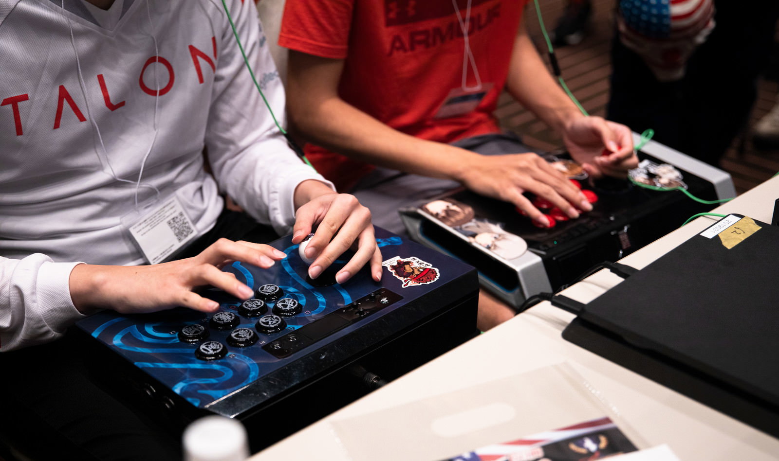 アーケードコントローラーを操作して対戦ゲームをプレイする複数の男性