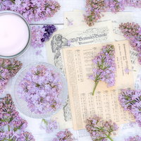 紫のライラックの花と楽譜、キャンドルなどの雑貨の写真
