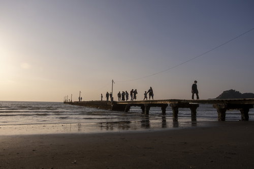 千葉県南房総市・原岡桟橋を渡る人々と夕暮れの海景観