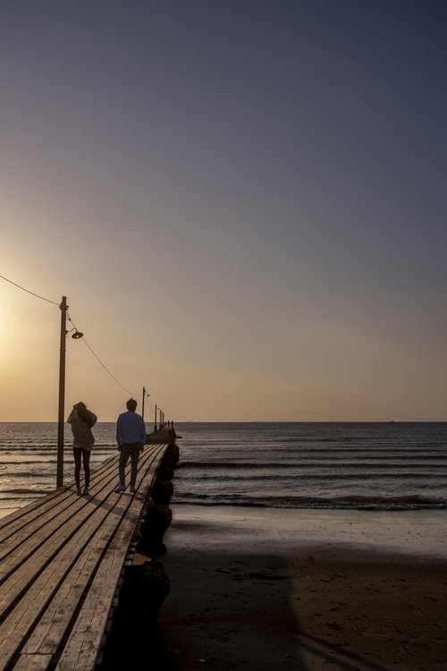 千葉県南房総市・原岡桟橋で夕日を背景にするデート中のカップル
