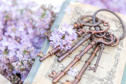 淡い紫のライラックに寄り添う古い鍵と洋書