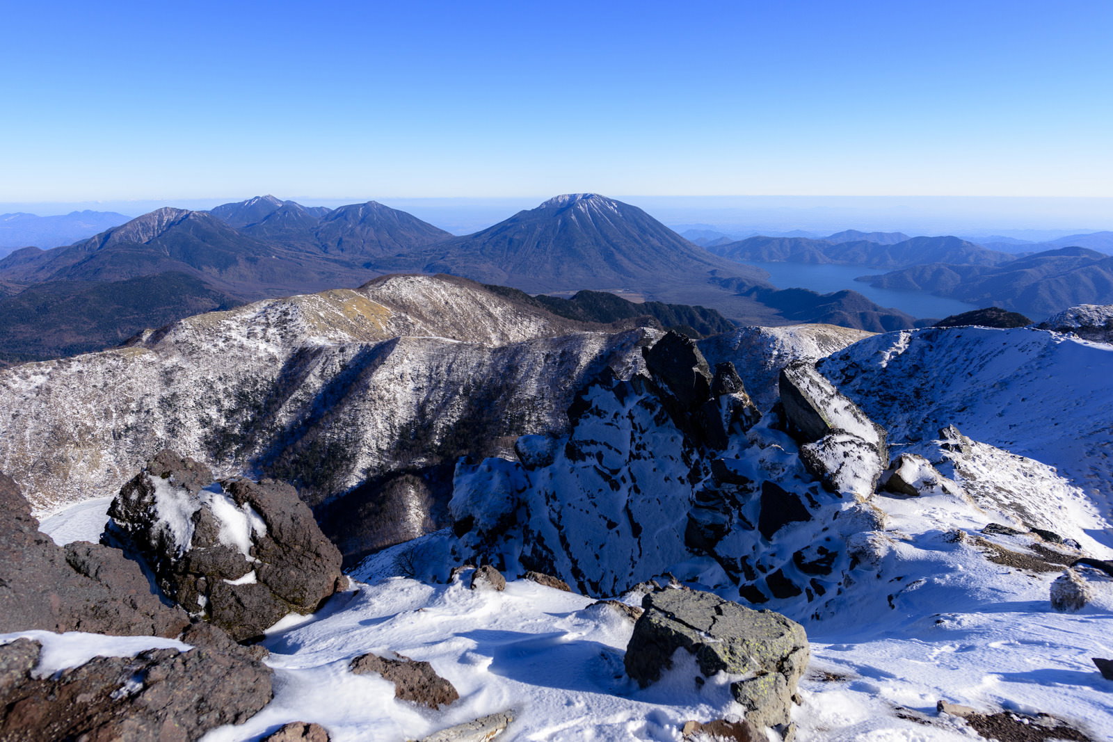 日光白根山から望む雪に覆われた日光連山の山並みと青空