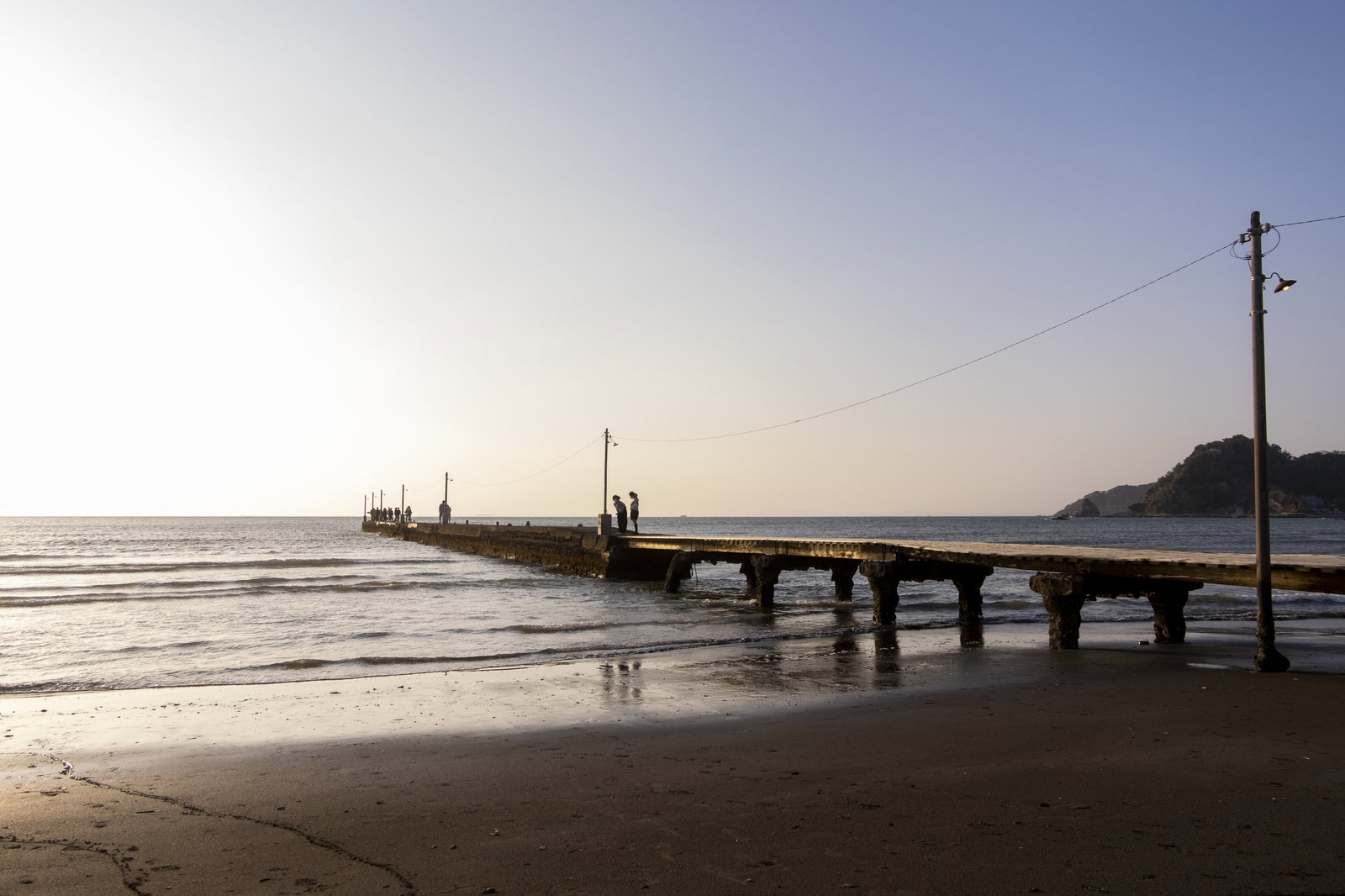 千葉県南房総市の原岡桟橋と波打ち際を夕暮れ時に捉えた海岸風景