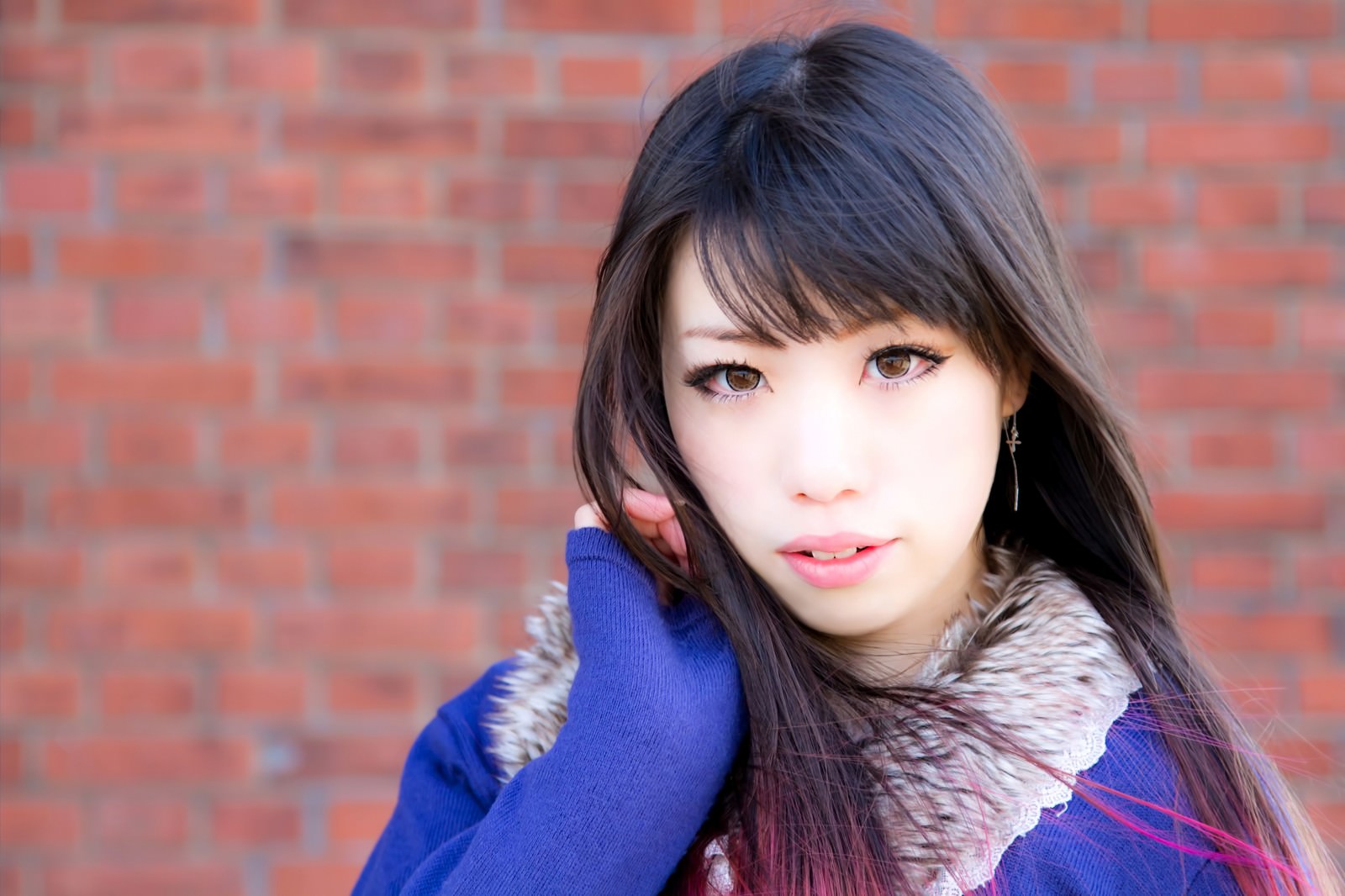 赤レンガ前で髪をかきあげる女性［モデル：大和くるみ］