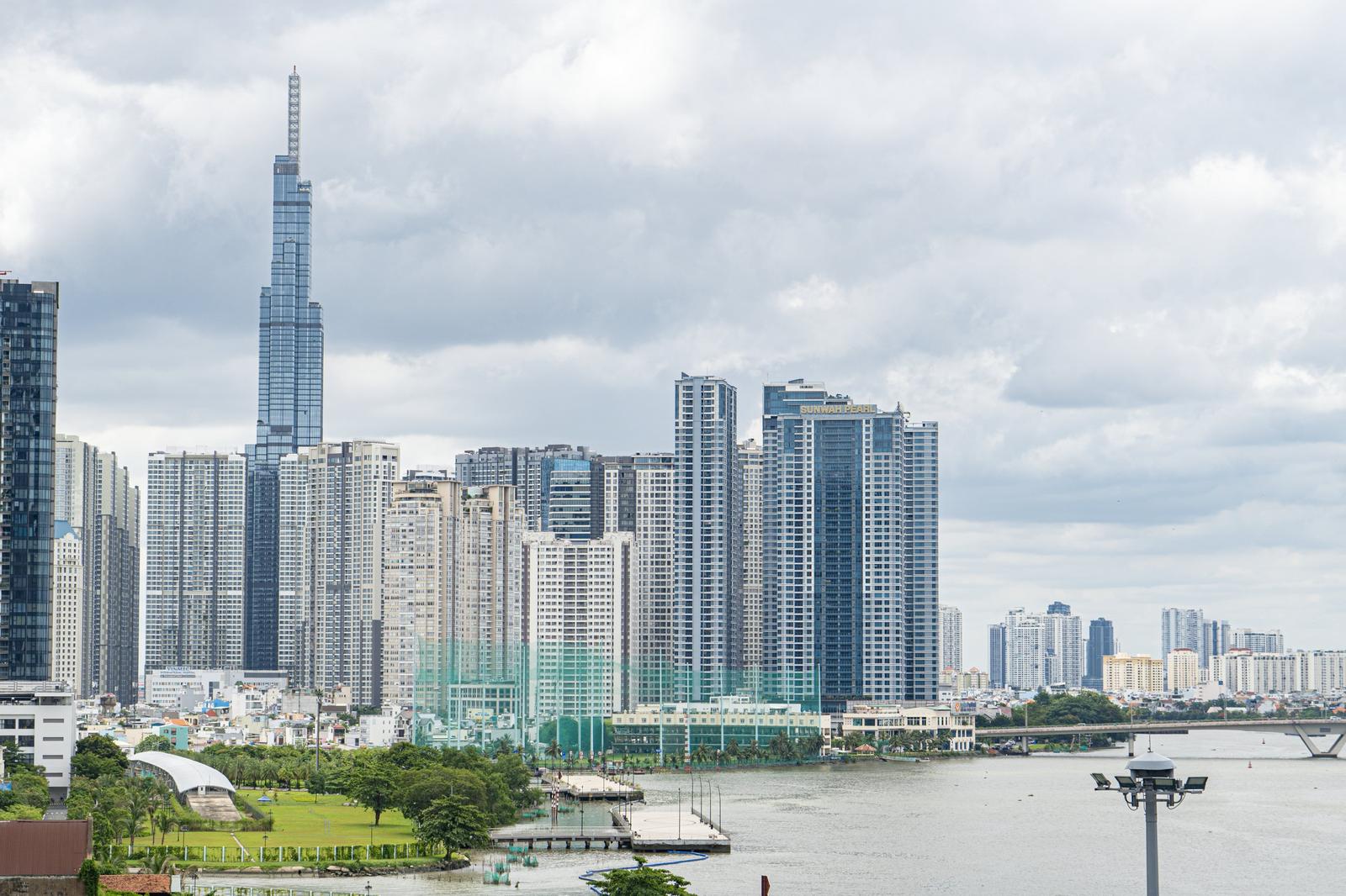 サイゴン川沿いに建つ高層ビル群と河岸の公園緑地の風景