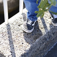 散歩中の子供が白と紺色のスニーカーで歩く足の写真
