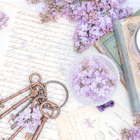 手紙に添えられた紫色のライラックと古書、鍵、キャンドルの雑貨の写真