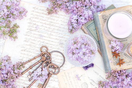 手紙に添えられた紫色のライラックと古書、鍵、キャンドルの雑貨