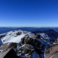 真っ青な空の下の日光白根山山頂から西側方面を望む雪景色の写真