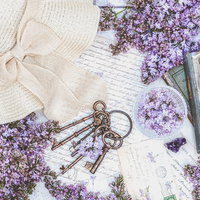 白いレースに麦わら帽子、アンティークな鍵とライラックの花を配置したフラットレイの写真