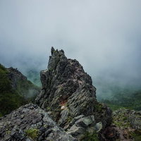 霧に覆われた日光白根山の岩稜の写真