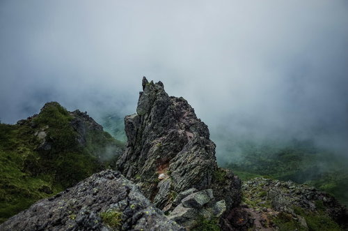 霧に包まれた日光白根山の鋭利に積み重なる岩稜