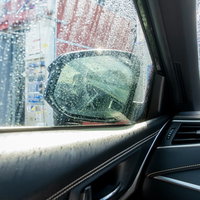 洗車中の車内のサイドガラスに付着した水滴の写真