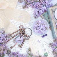 白いテーブルに紫のライラックと鍵、洋書、帽子を配置した雑貨の写真