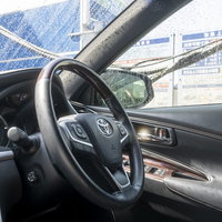 洗車中の誰もいない運転席のステアリングハンドルの写真