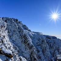 陽光照り付ける日光白根山の氷の岸壁と光芒の写真