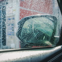 雨の日の車内から見るサイドミラーとサイドガラスの写真