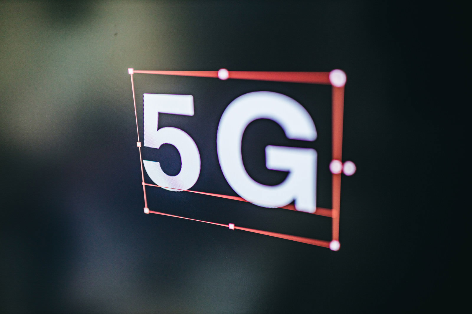 暗い背景に光る白い5Gの文字が赤いフレームで囲まれている