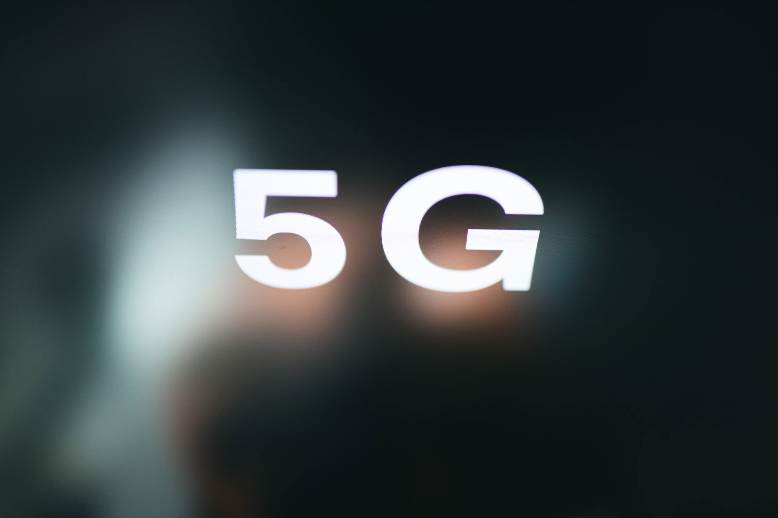 暗い背景に白く光る5Gの文字が浮かび上がっている