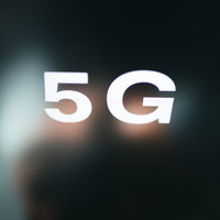 暗い背景に白く光る5Gの文字のデジタル表現の写真
