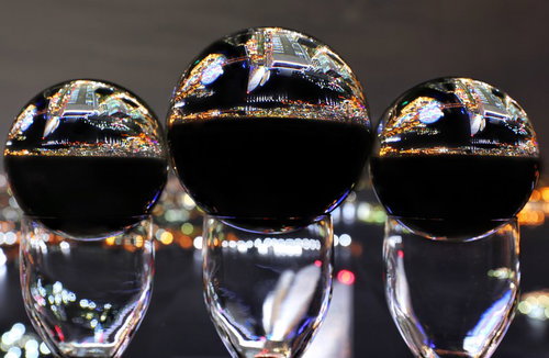 グラスの上に乗った水晶玉に映る都会の夜景