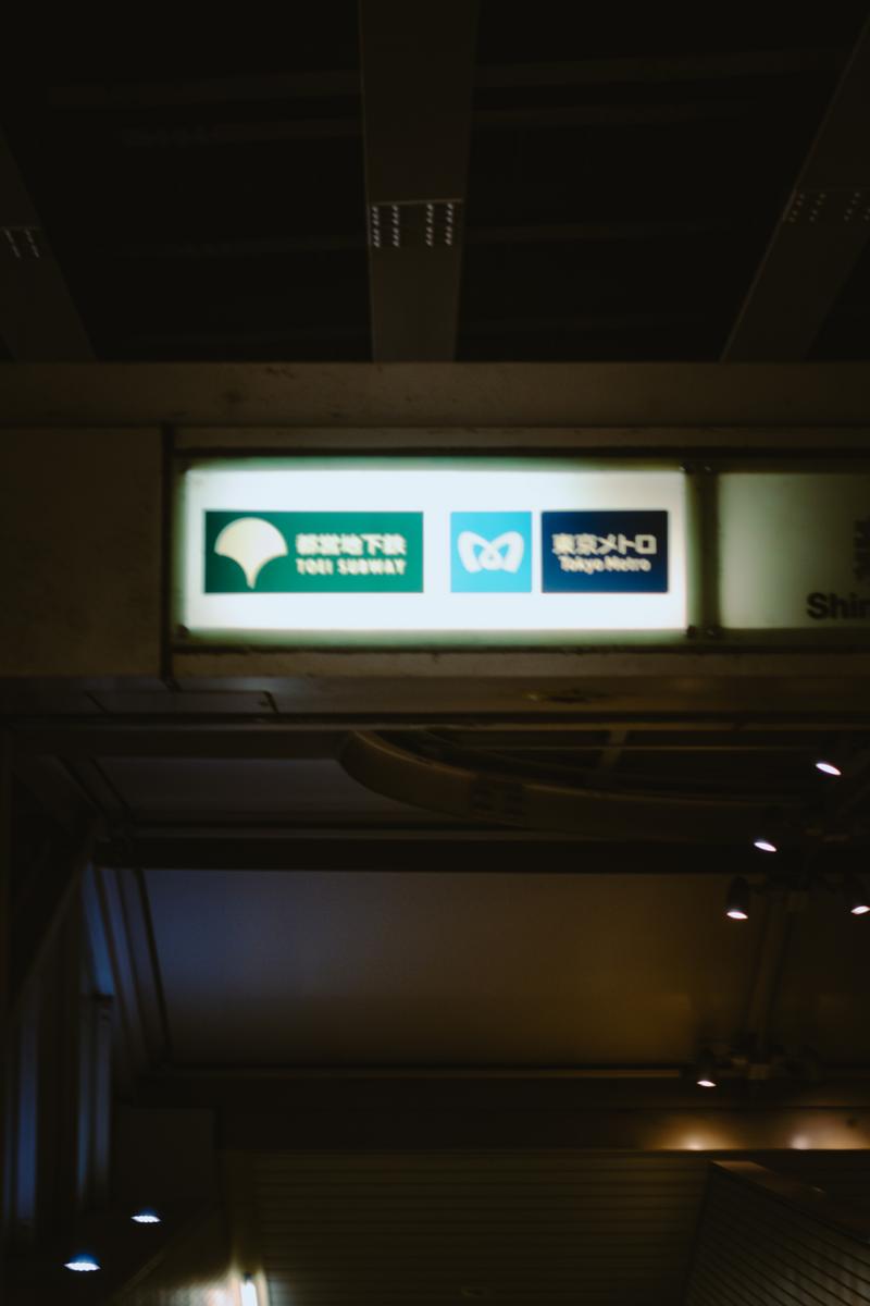 夜間の駅構内に設置された都営地下鉄と東京メトロの照らされた案内板