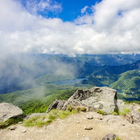 雲と青空が広がる日本百名山・日光白根山の山頂景色の写真