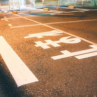 道路に描かれた止まれの位置を示す白い路面標示の写真