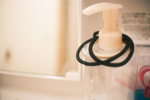 洗面台に置かれたプッシュボトルとヘアゴム